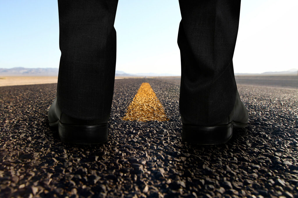 feet of person staring down a long road